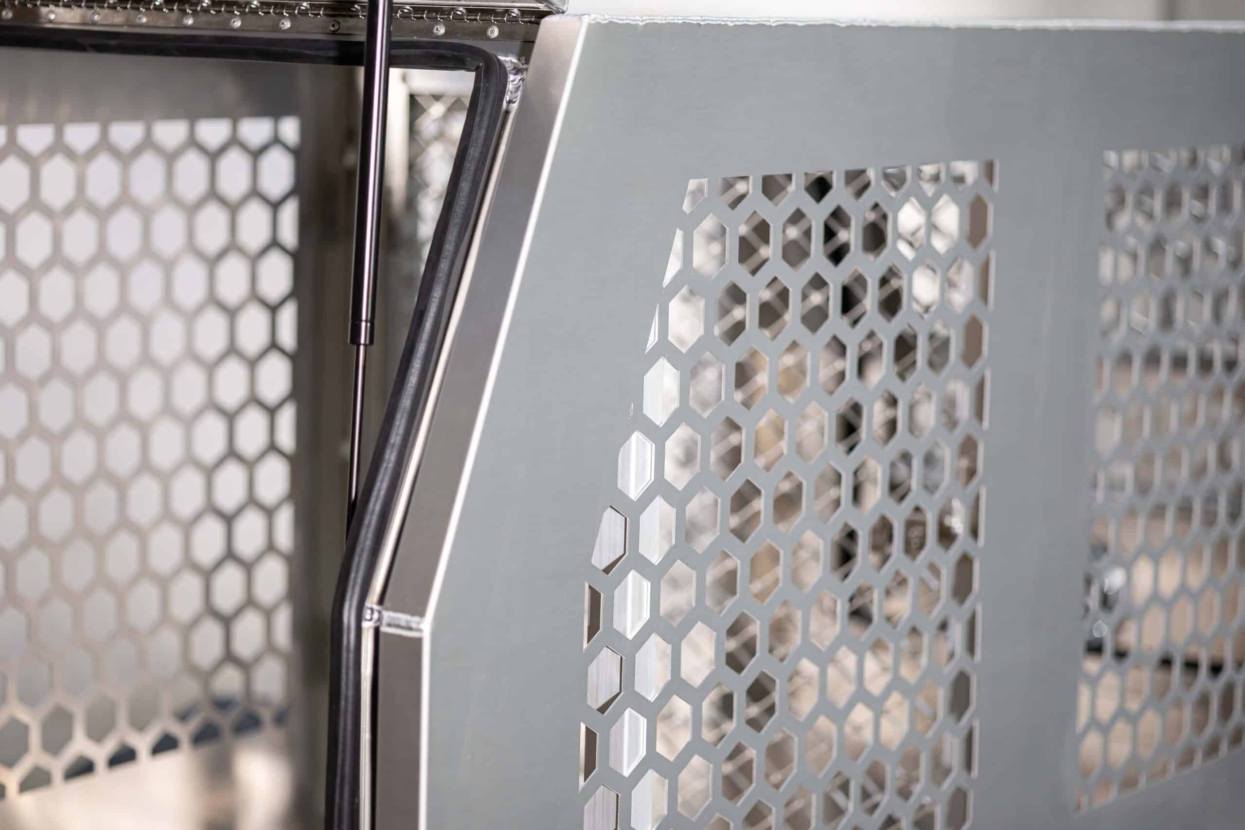 Close-up of the dog box ventilation panel and gas strut support inside the aluminium canopy