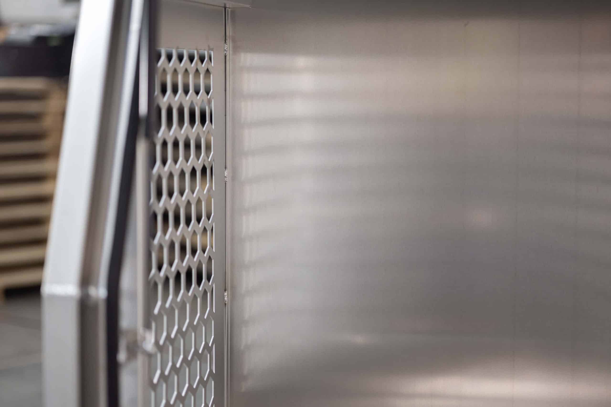 Interior of UTE dog box with clean alloy walls and ventilation panels