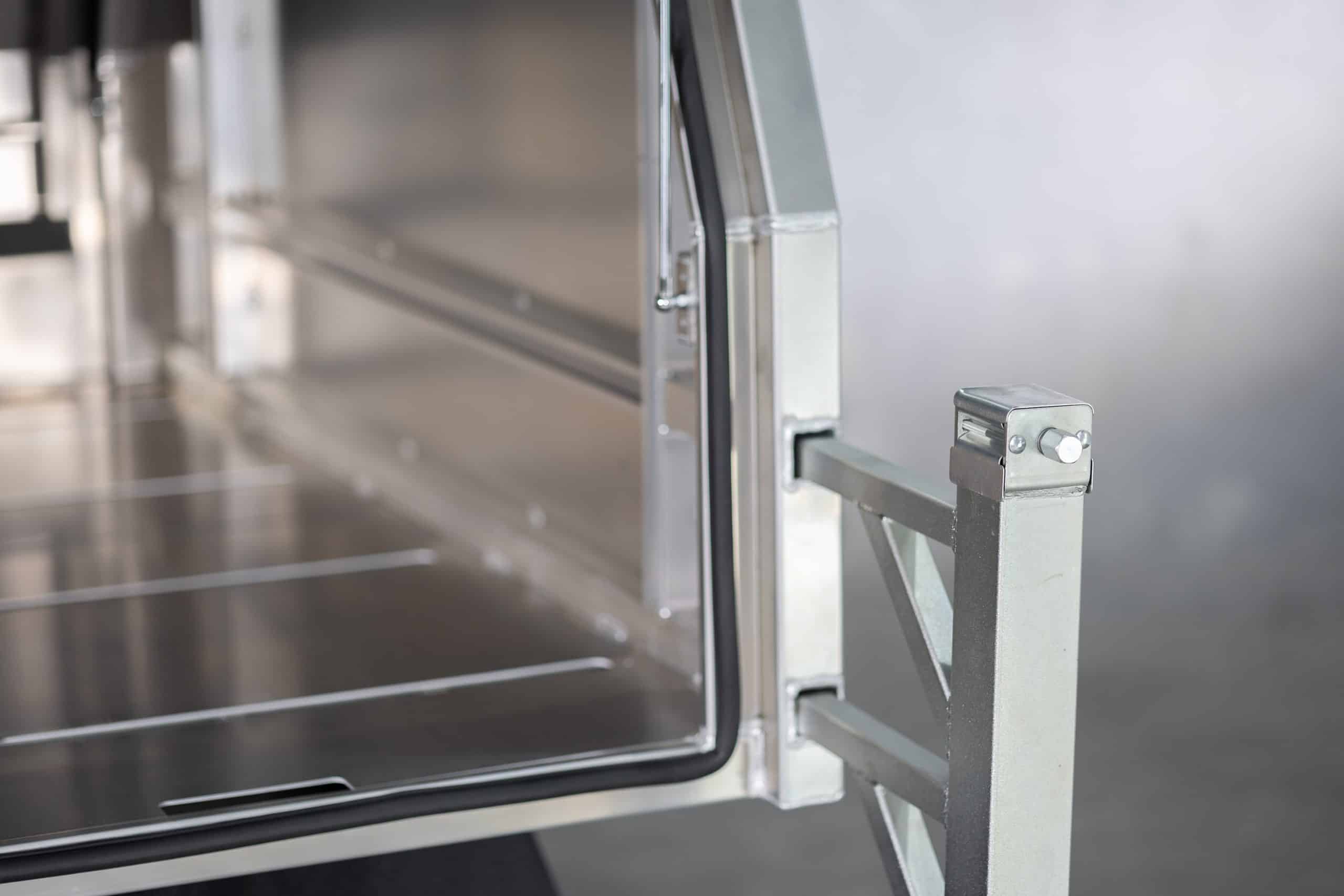 Close-up of UTE canopy’s door hinge and support arm assembly