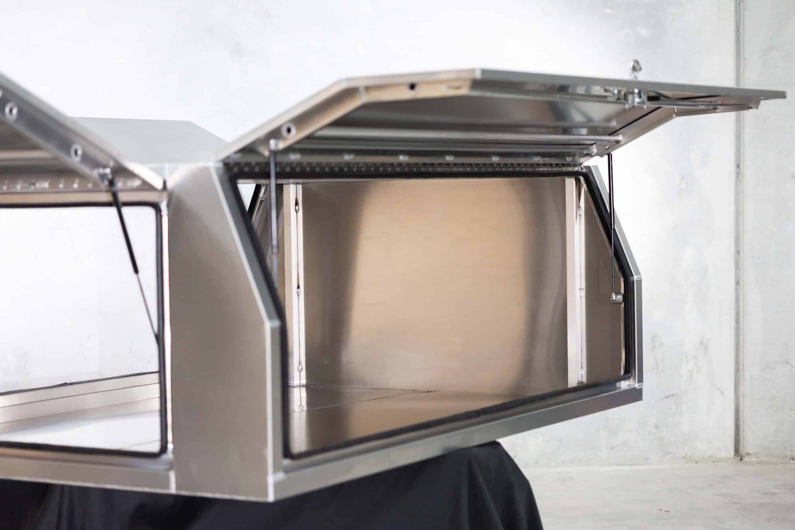 Aluminium UTE canopy with side doors open upwards, showing the spacious interior and reinforced frame