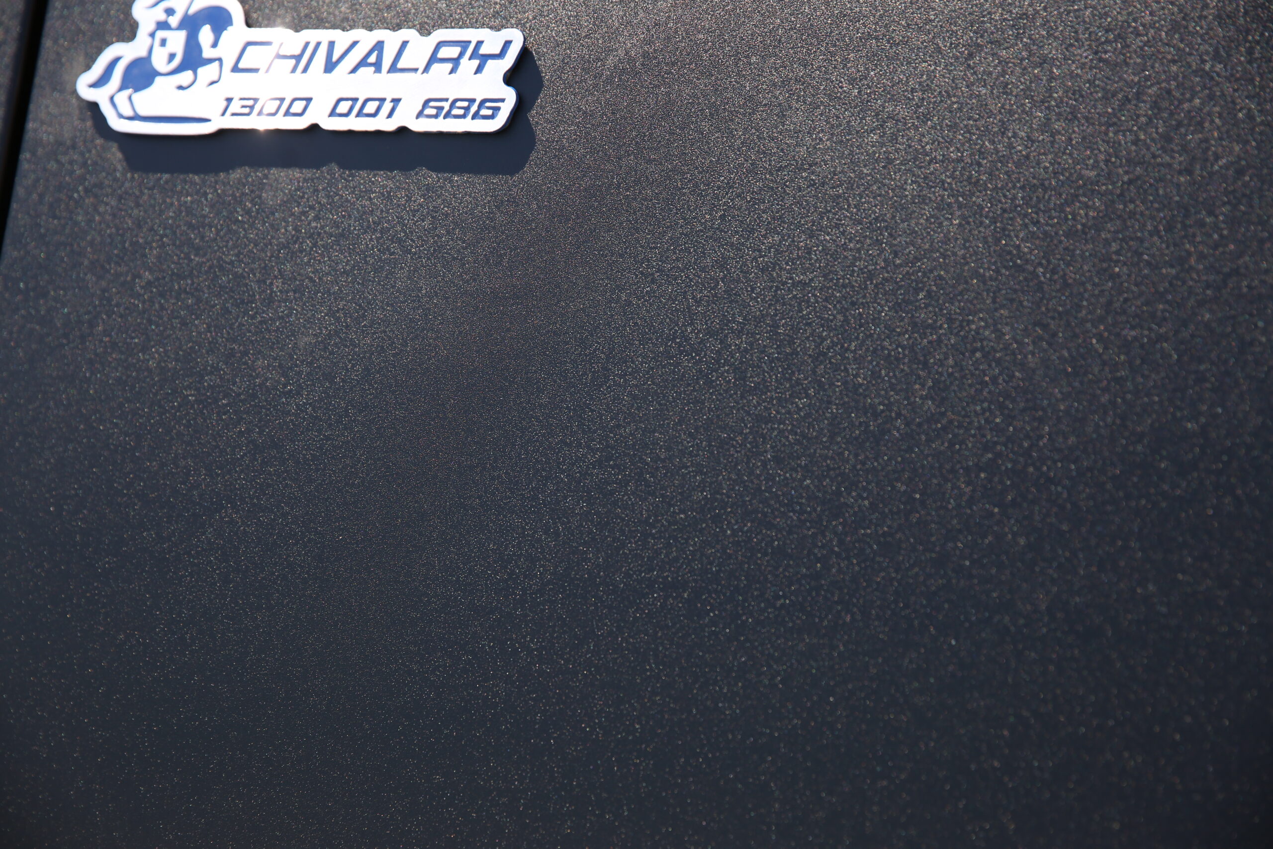 Close-up of the Chivalry metal logo badge on a UTE canopy surface