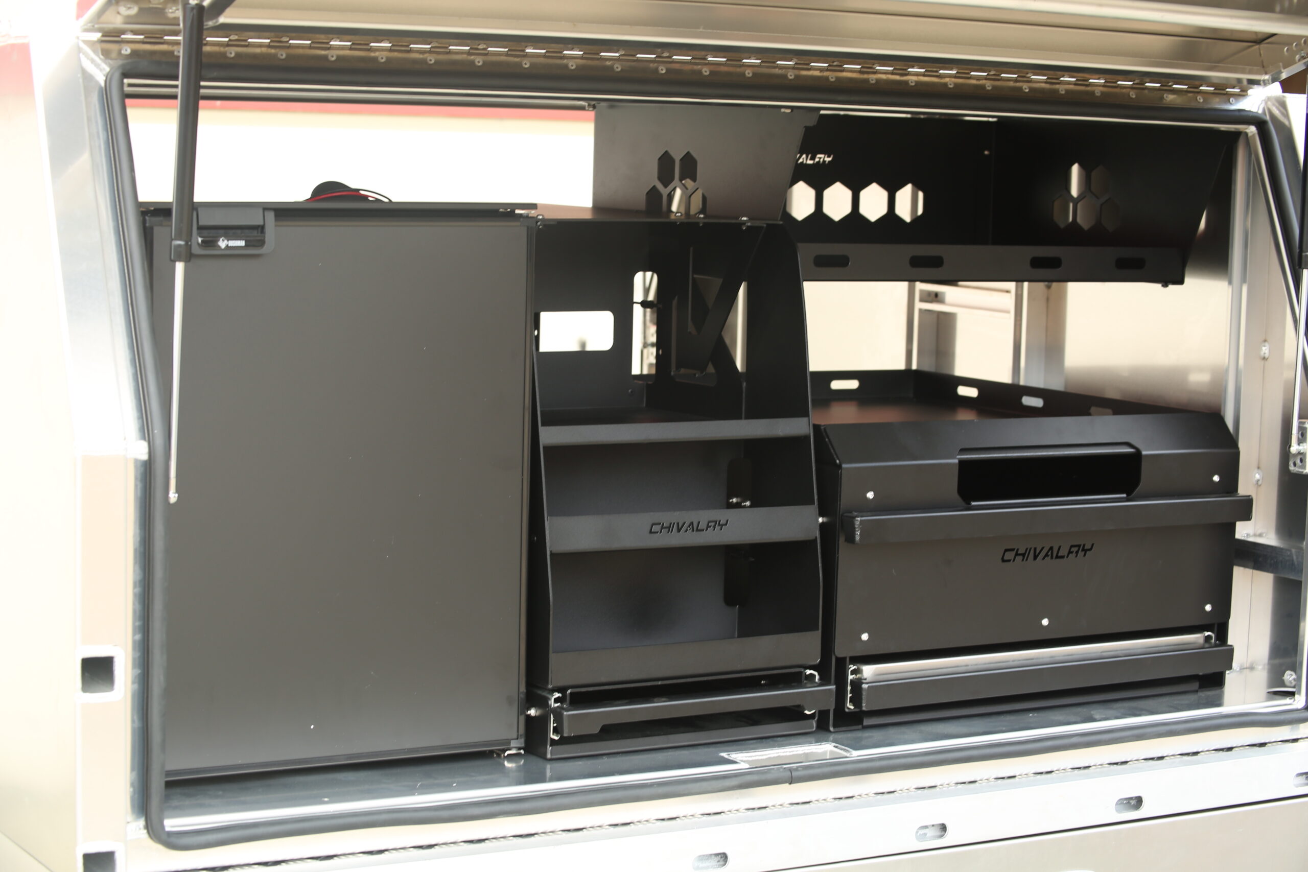 Interior storage setup of UTE canopy featuring moldular drawer system, fridge and organised shelving from Oz Chivalry